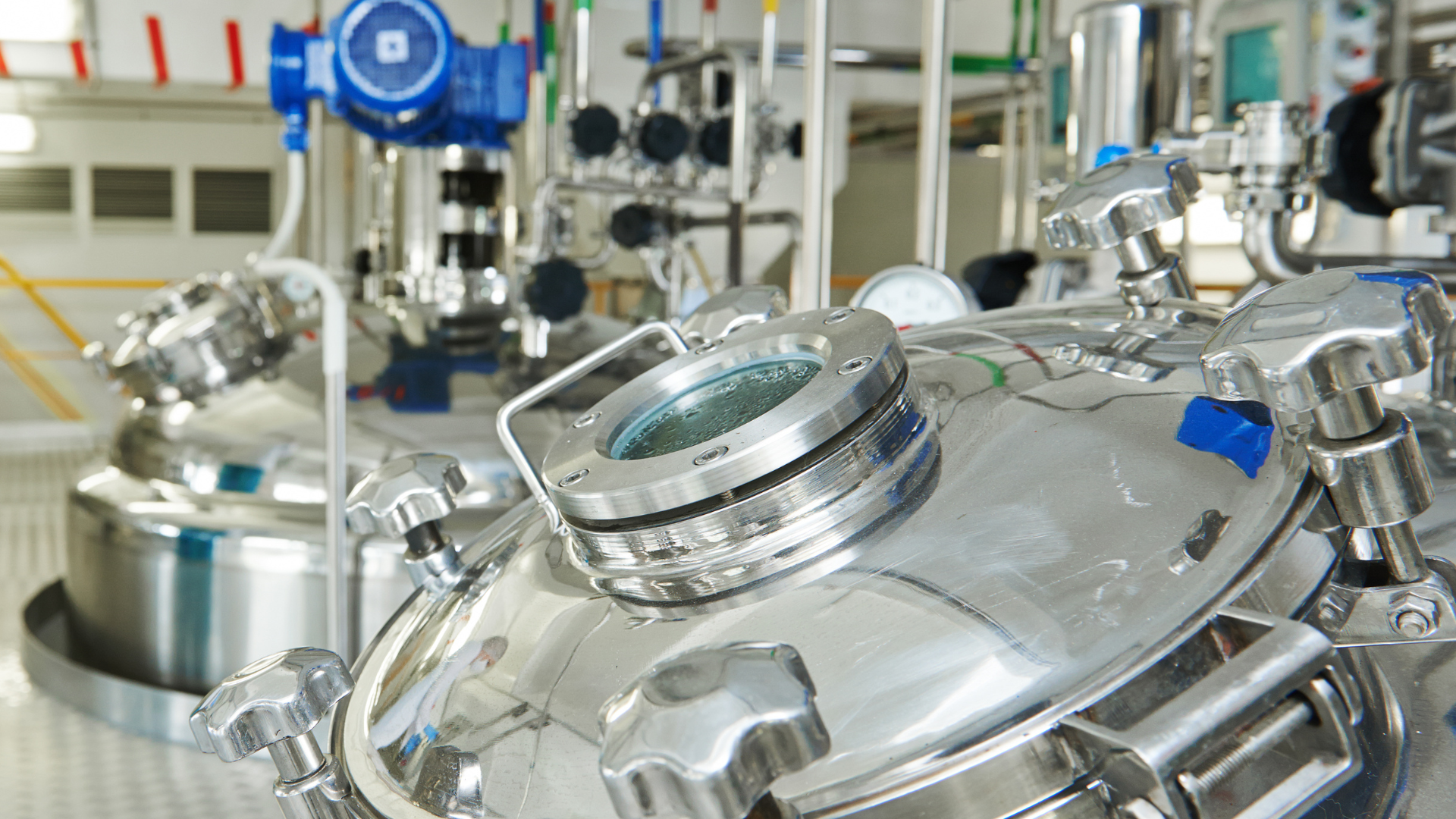 A stainless steel tank with a glass lid in a factory.