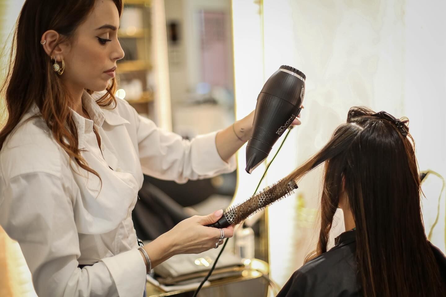 Parrucchiera durante la fase di asciugatura dei capelli