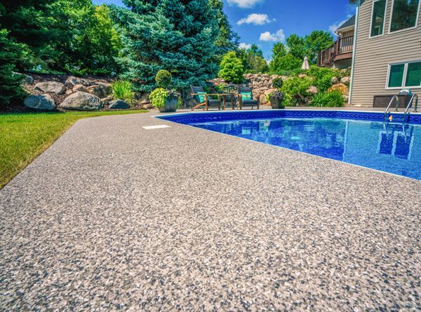There is a large swimming pool in the backyard of a house.