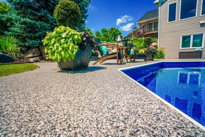 There is a swimming pool in the backyard of a house.