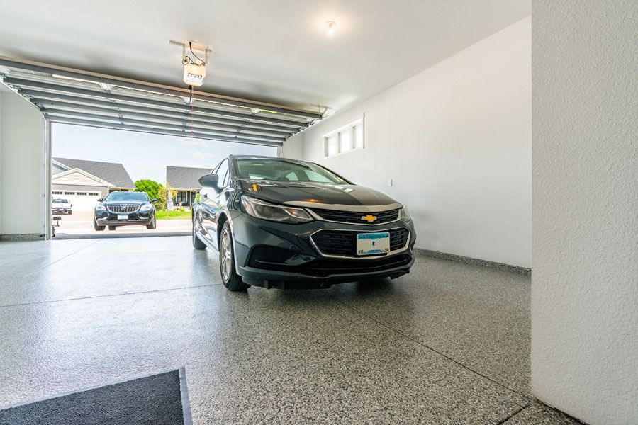 A car is parked in a garage with the door open.