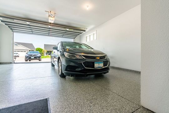 Car parked in an open garage with a premium floor coating.