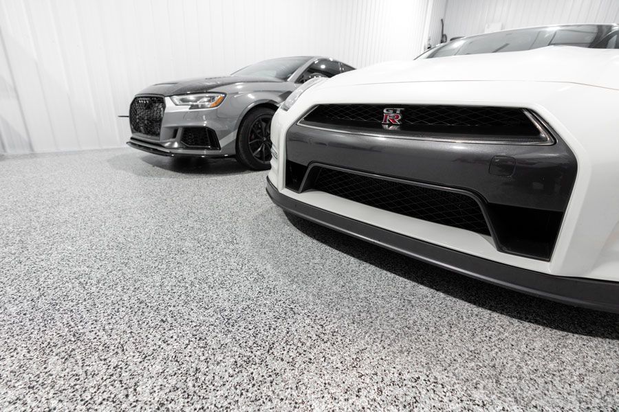 Two cars are parked next to each other in a garage.