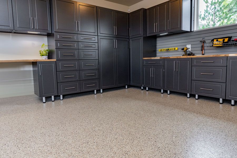 A large garage with lots of cabinets and drawers and a concrete floor.