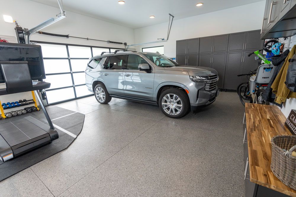 A car is parked in a garage next to a treadmill.