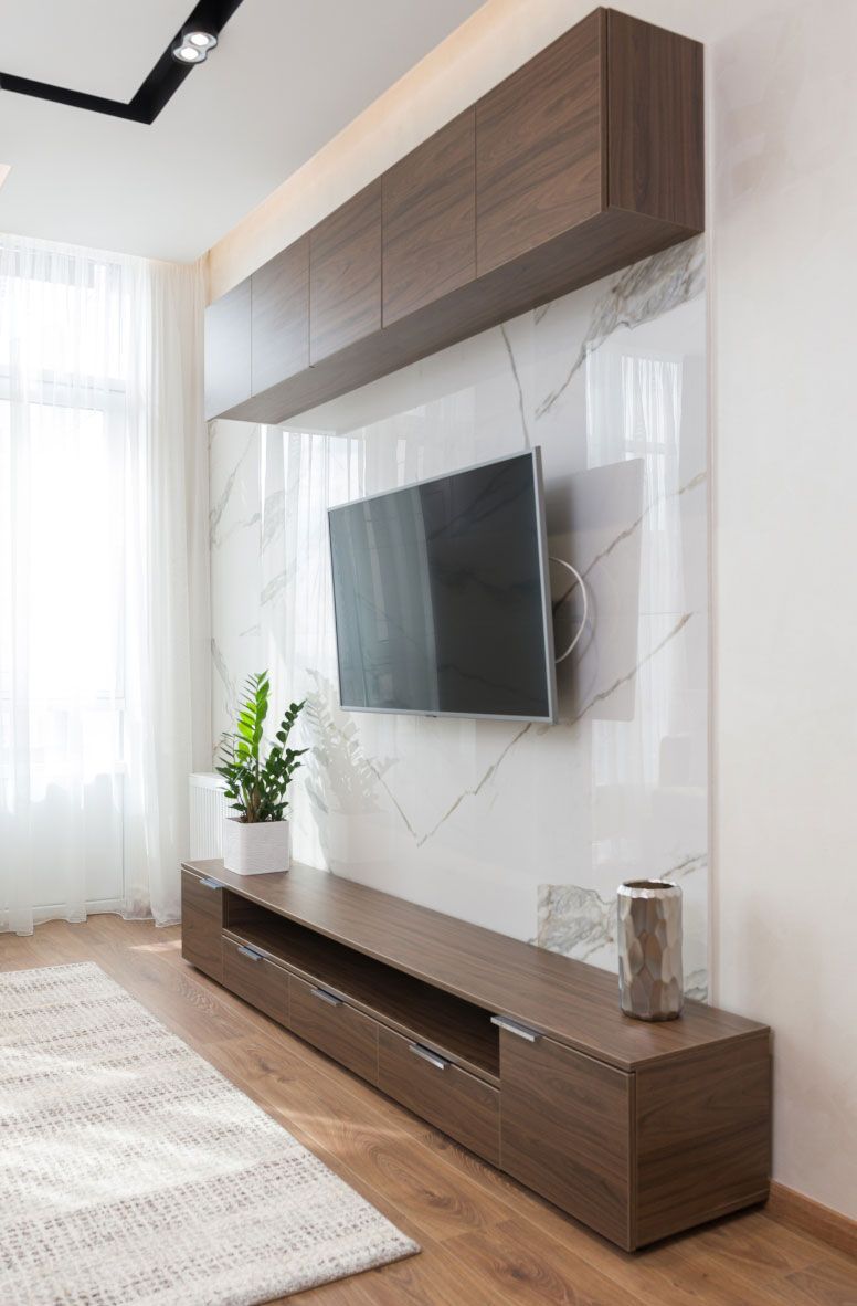 A living room with a flat screen tv mounted on the wall.