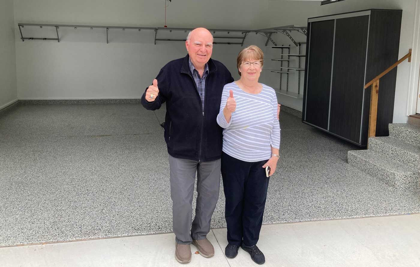 Customers are standing in a garage giving a thumbs up.