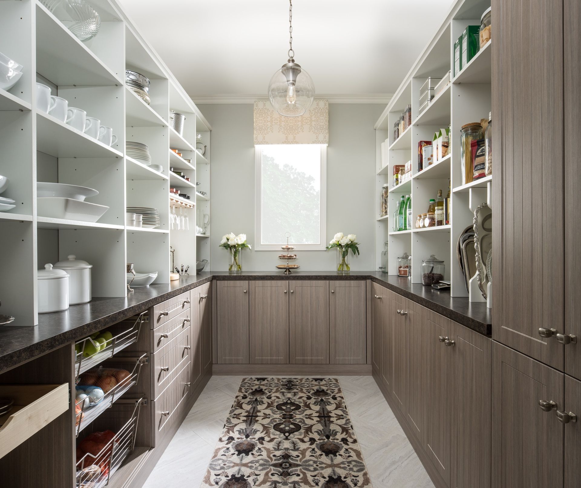 A kitchen pantry with lots of shelves and cabinets and a rug on the floor