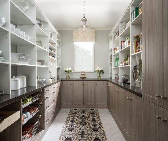 A kitchen with lots of shelves and cabinets and a rug on the floor