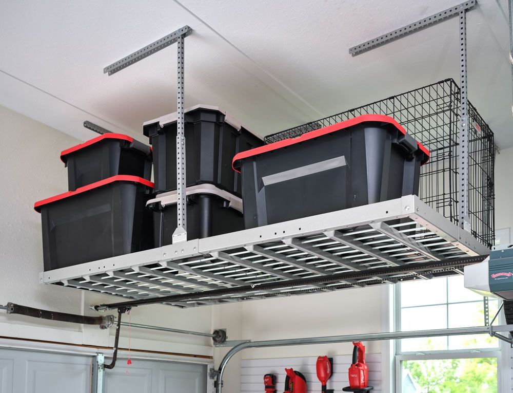 A garage with a ceiling rack filled with black bins.