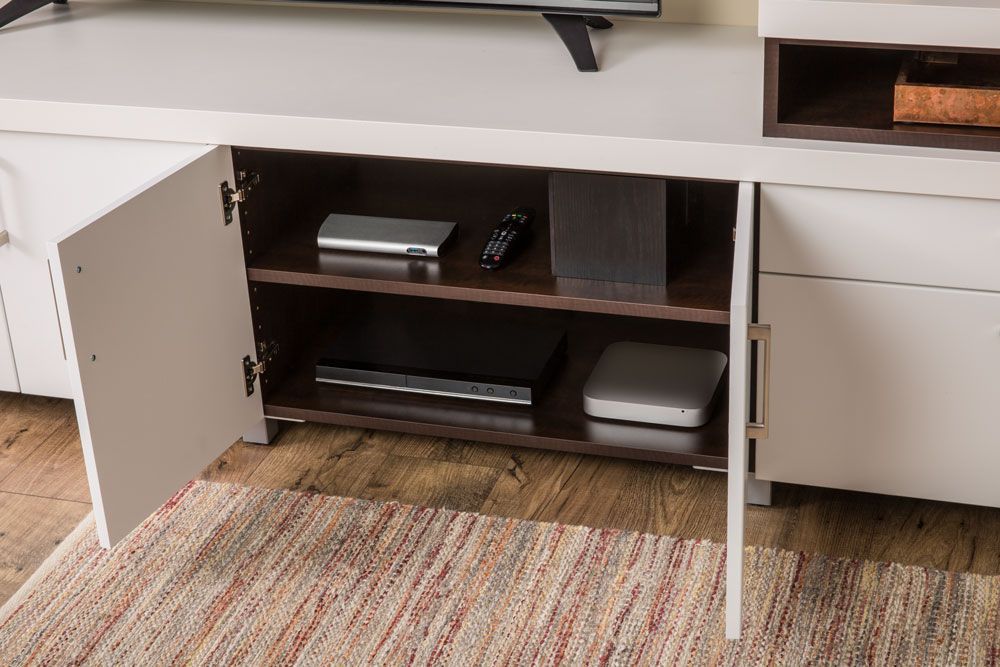 A television is sitting on top of a white entertainment center with the doors open.