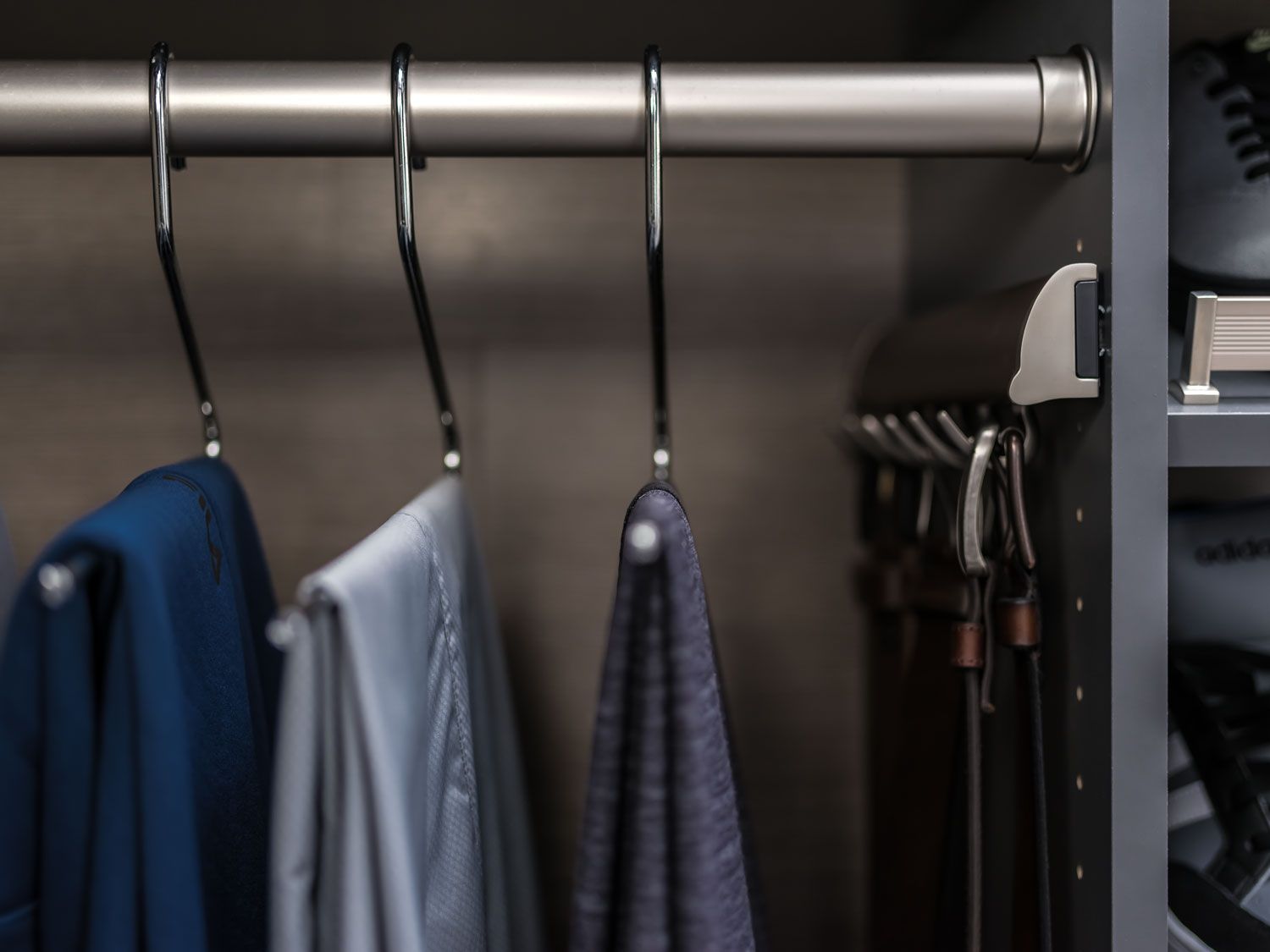 A closet filled with clothes and a tie rack.