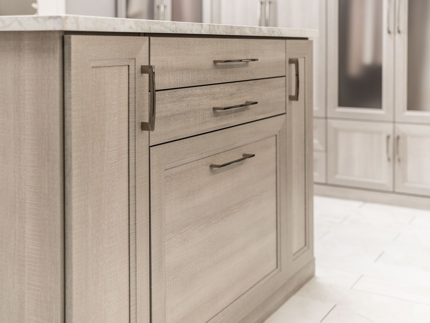 A kitchen with wooden cabinets and drawers and a marble counter top.