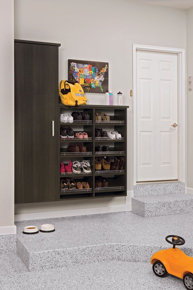 There is a toy car in the garage next to a shoe rack.