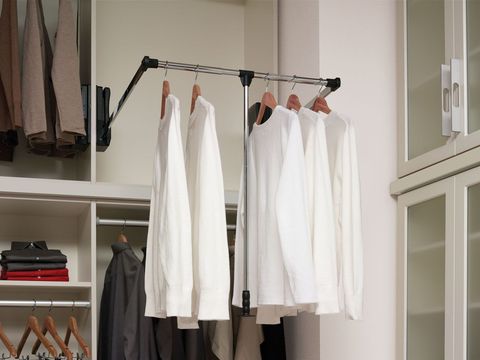 Clothes are hanging on a rack in a closet.