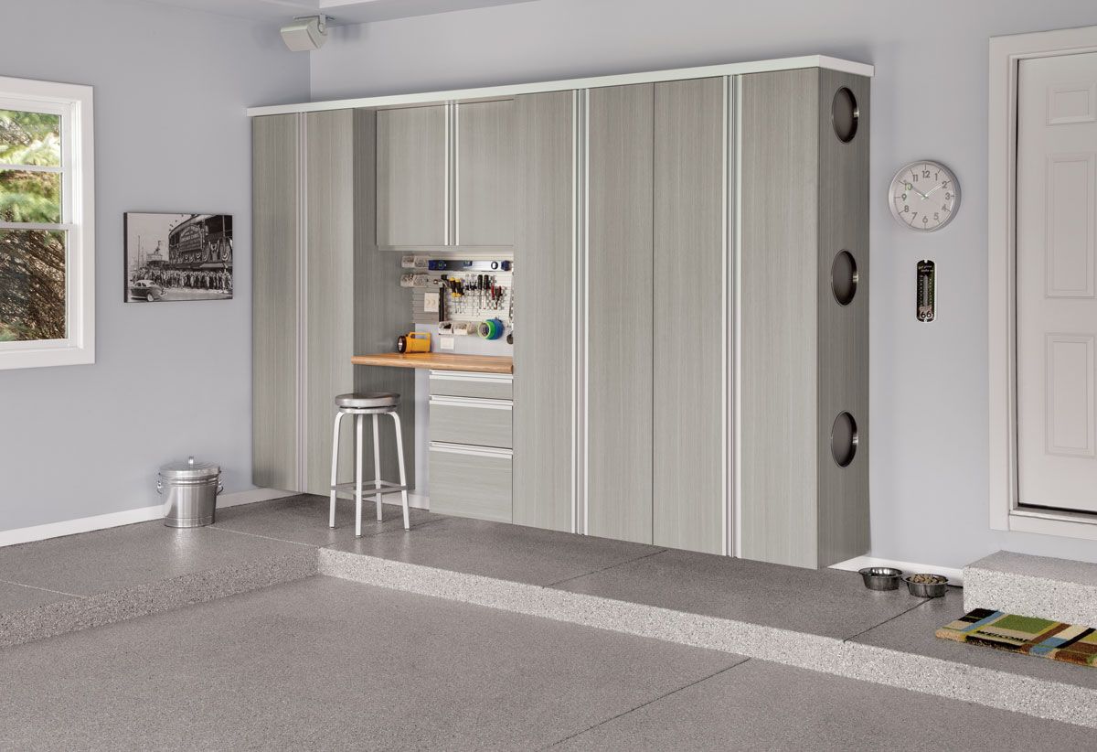 A garage with a lot of cabinets and a clock on the wall.