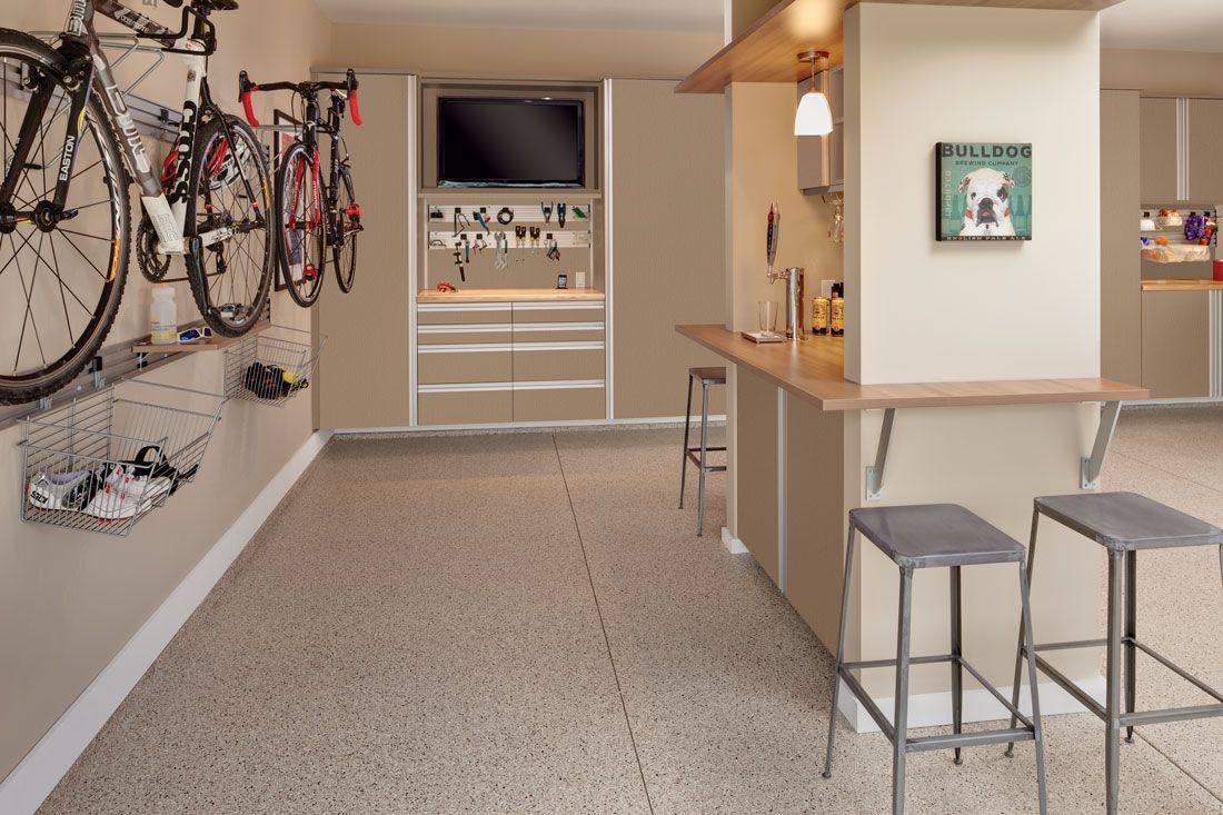 Two bicycles are hanging on a wall in a garage.