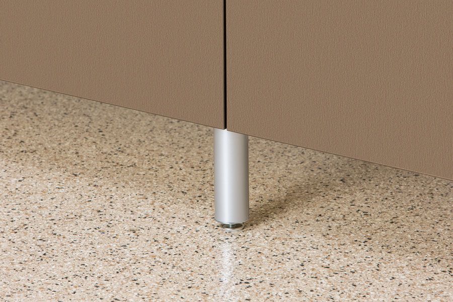A metal pole is sitting on a marble floor next to a wall.