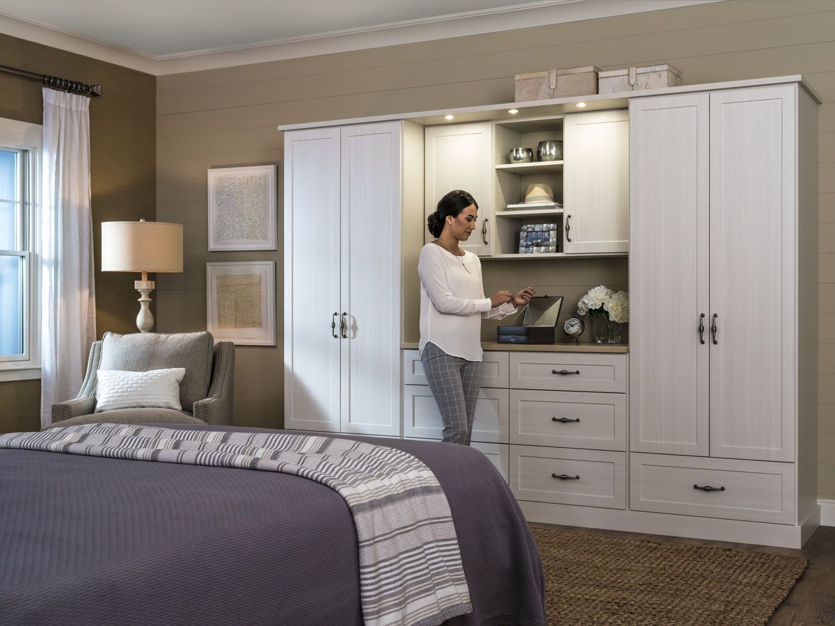 Woman reaching for an item in her custom reach-in closet.
