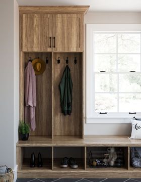 A mud room with wooden cabinets , a bench , and a window.