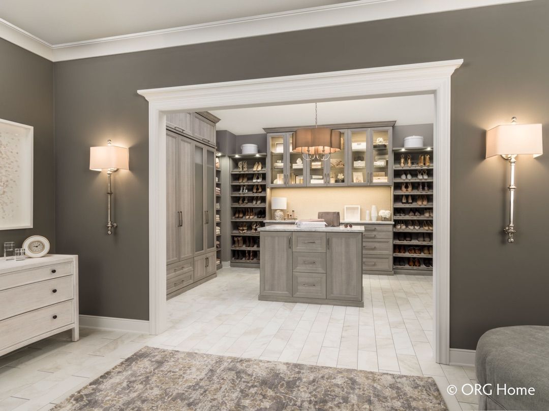 A walk in closet with a large island in the middle of it