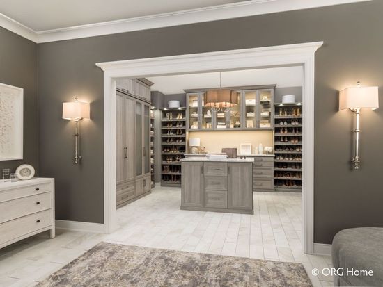 A walk in closet with a large island in the middle of it