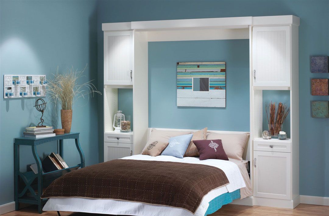 A bedroom with a bed and a painting on the wall.