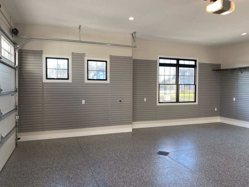 An empty garage with a gray wall and a gray floor.