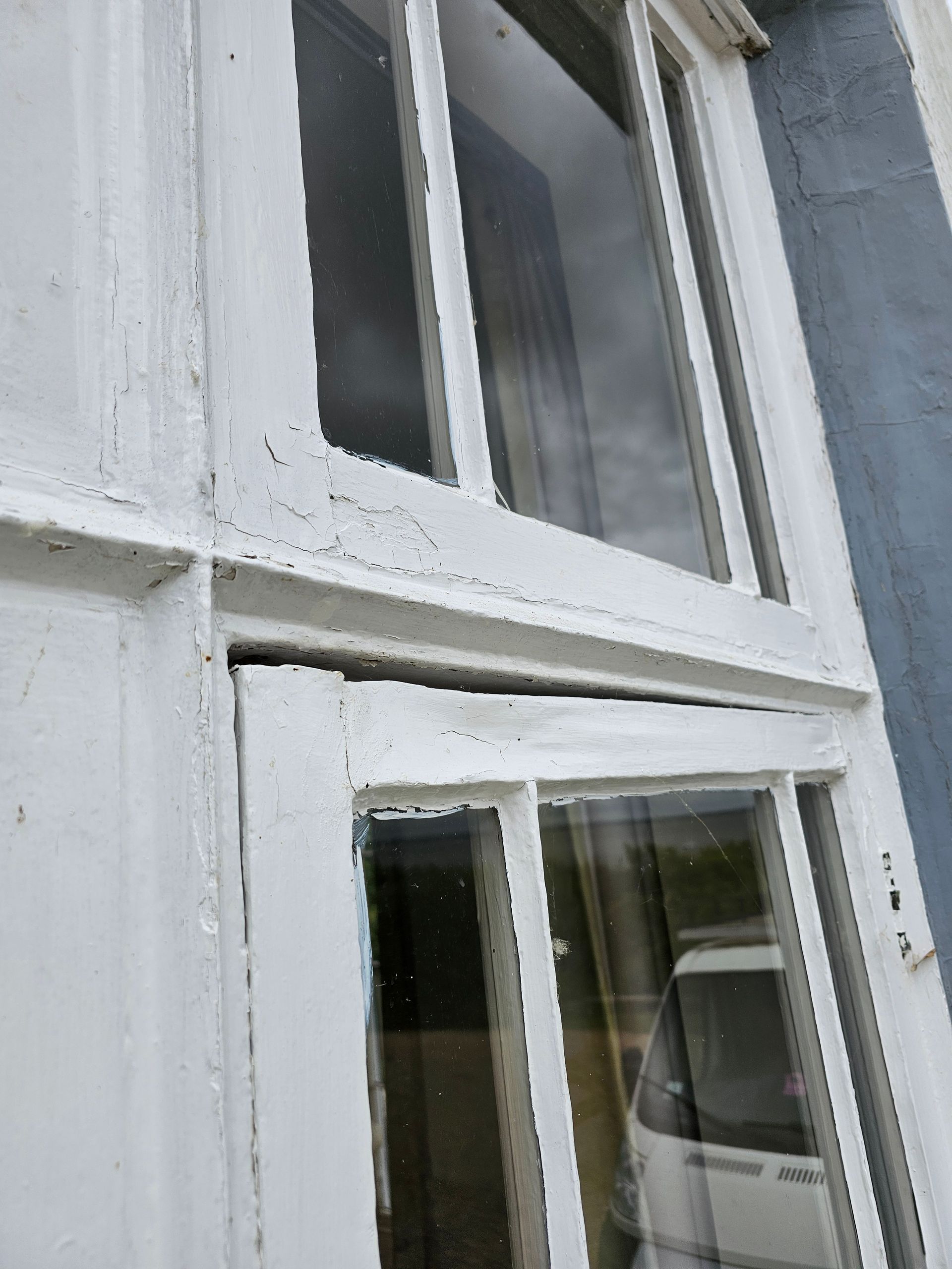 A white window with a reflection of a car in it