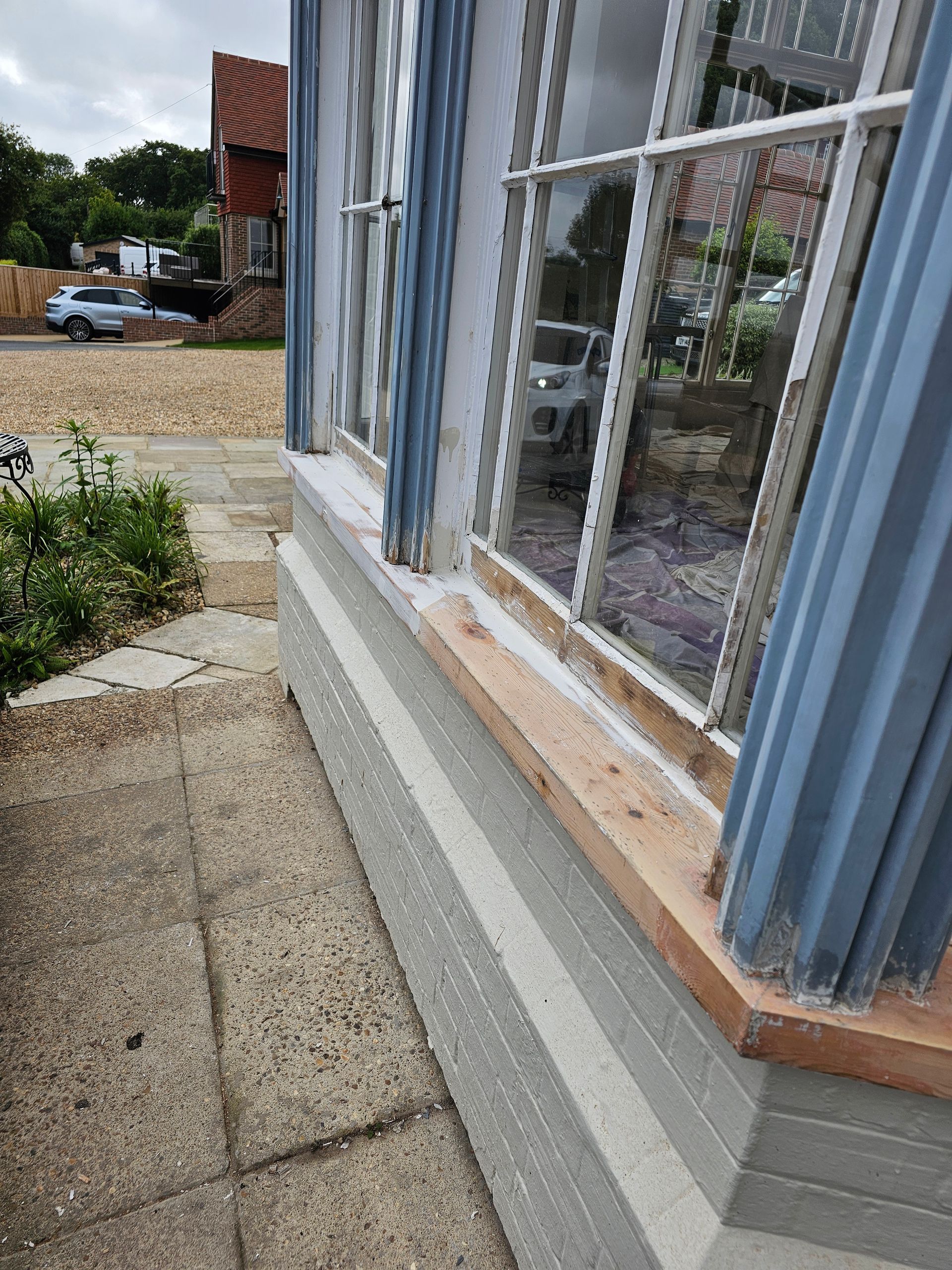 A window with a wooden sill is on the side of a building.