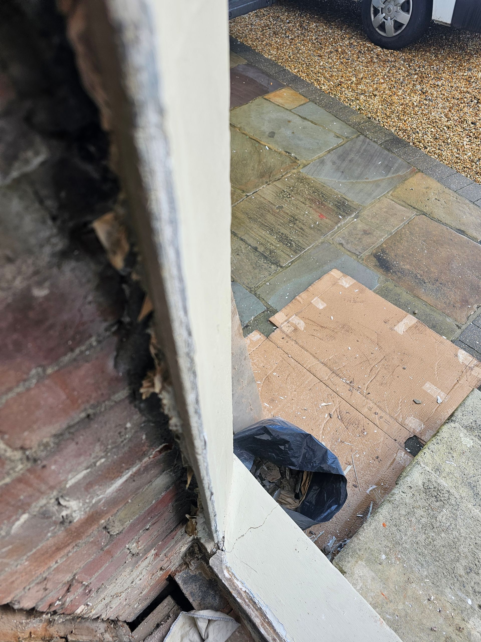 A car is parked on the side of the road next to a brick walkway.