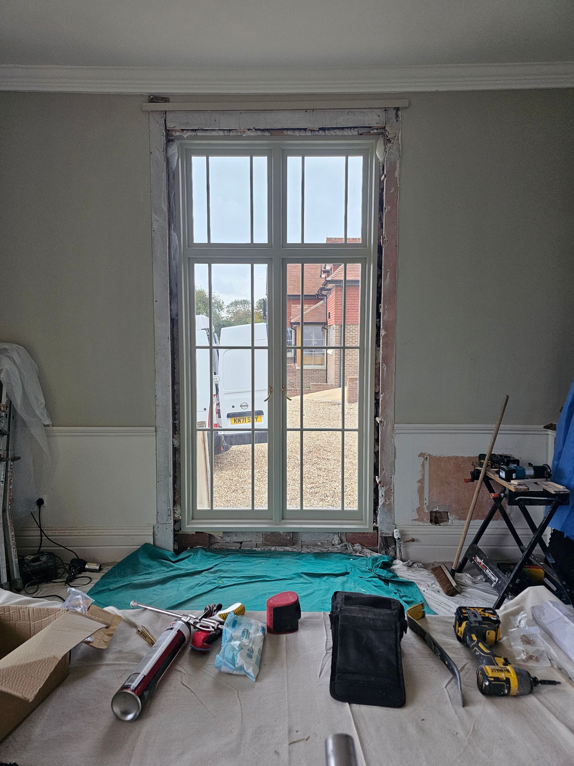 A room with a large window and a lot of tools on the floor.