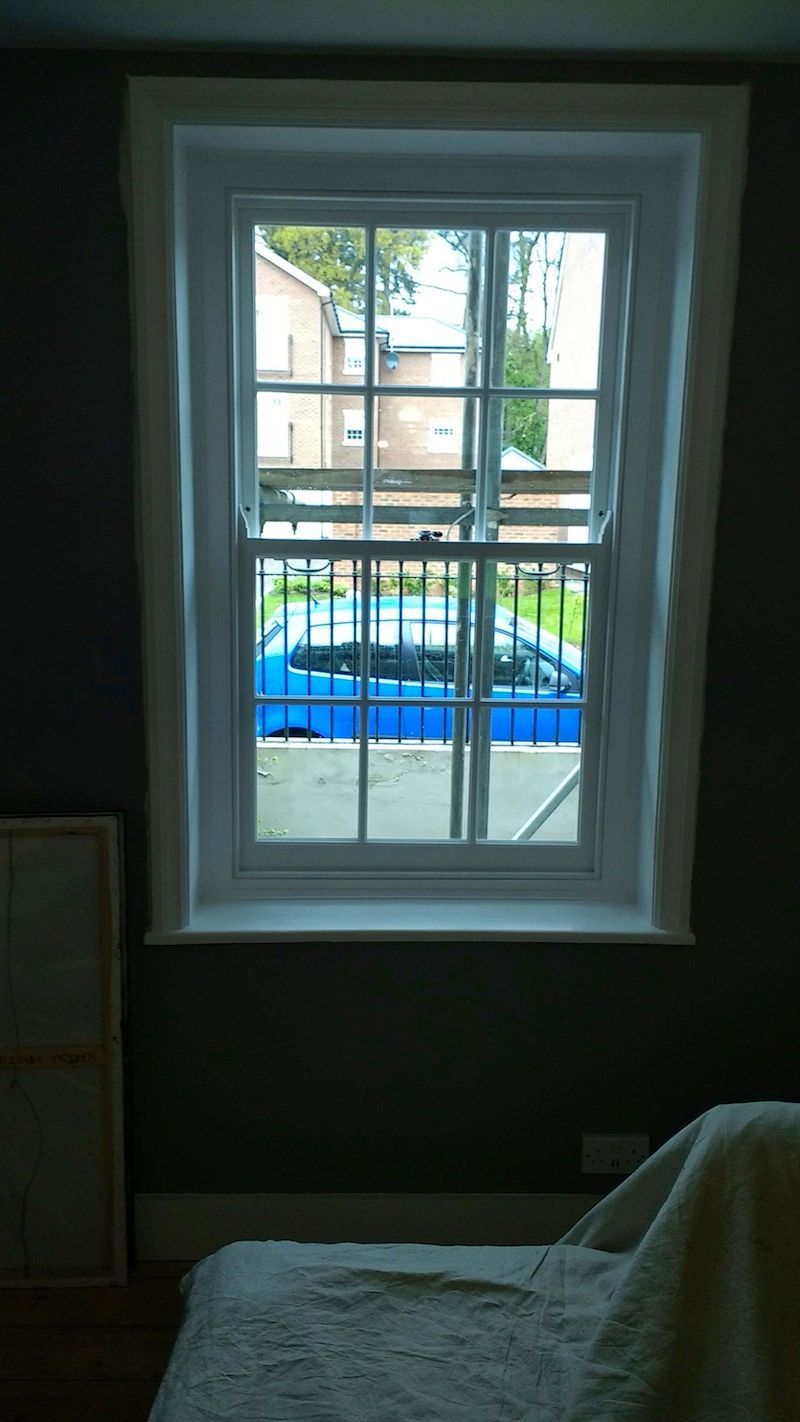 A window in a room with a couch in front of it.