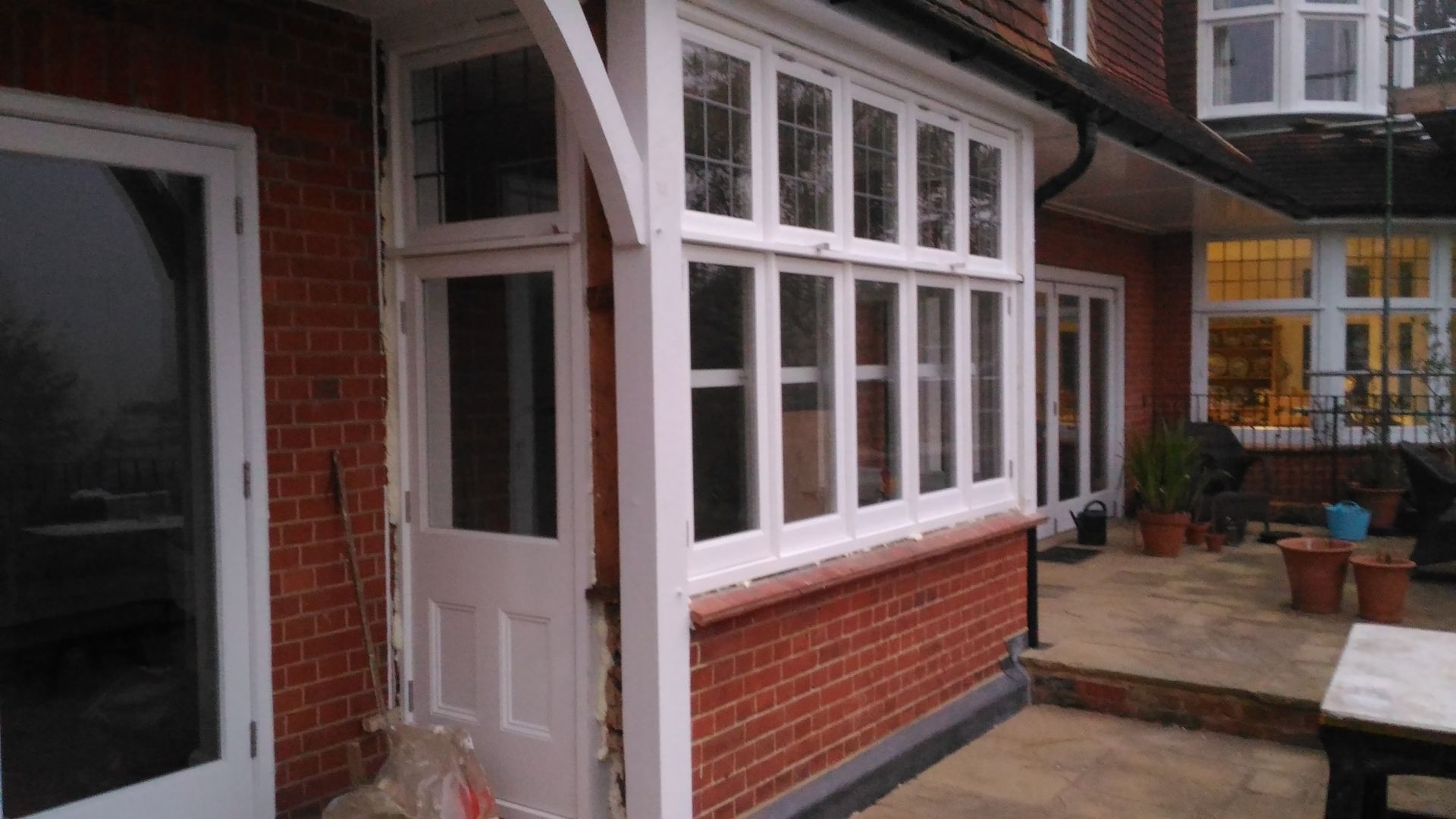 A brick house with a porch with a lot of windows