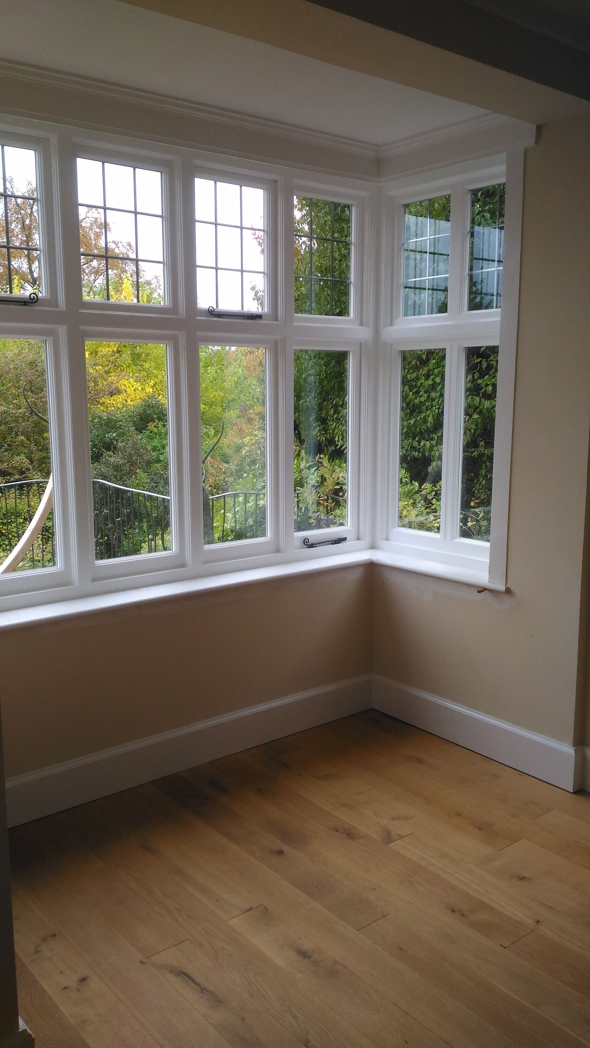 A room with a large window and a wooden floor.
