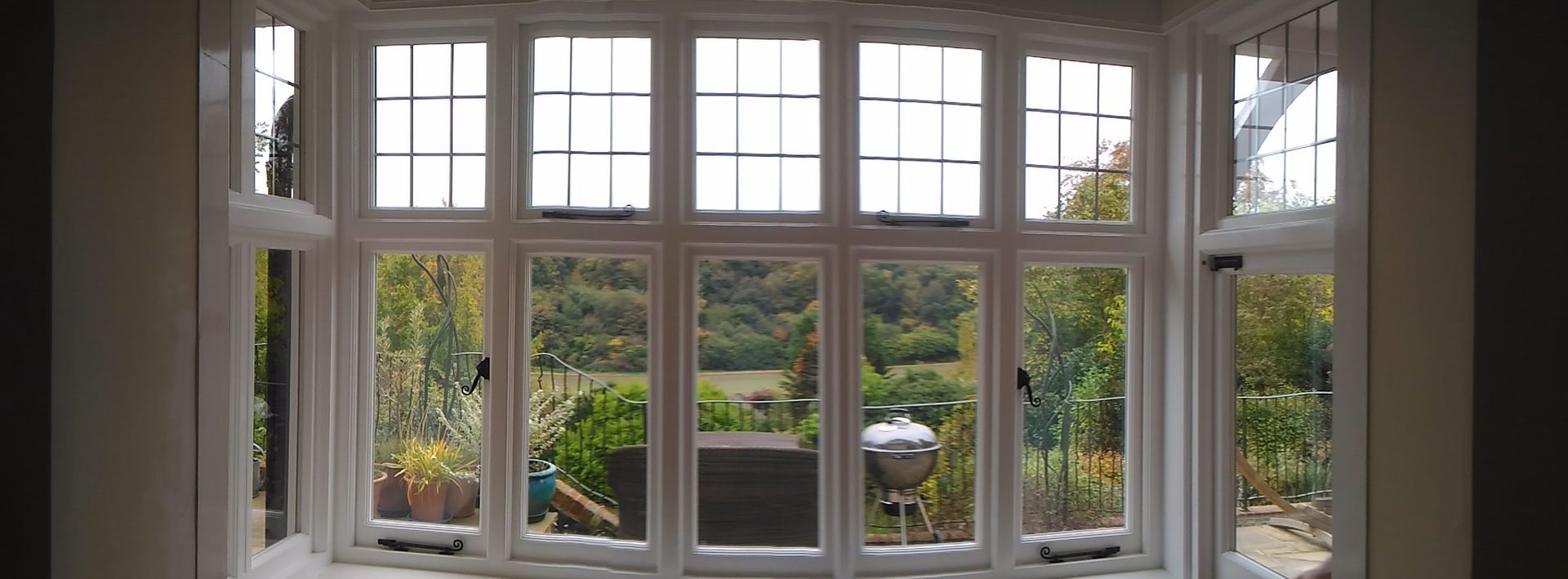 A room with a lot of windows and a view of a garden