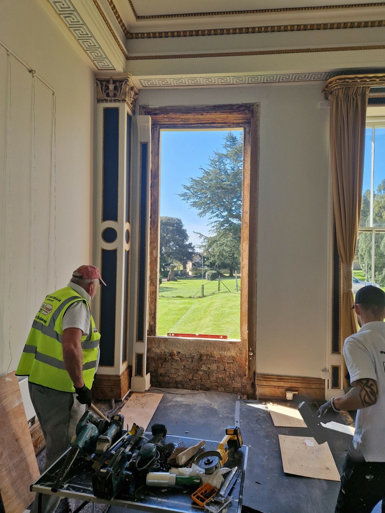 a workman from Sussex Sash wearing a hi-viz vest and working on replacing sash windows at Northwood House, isle of Wight