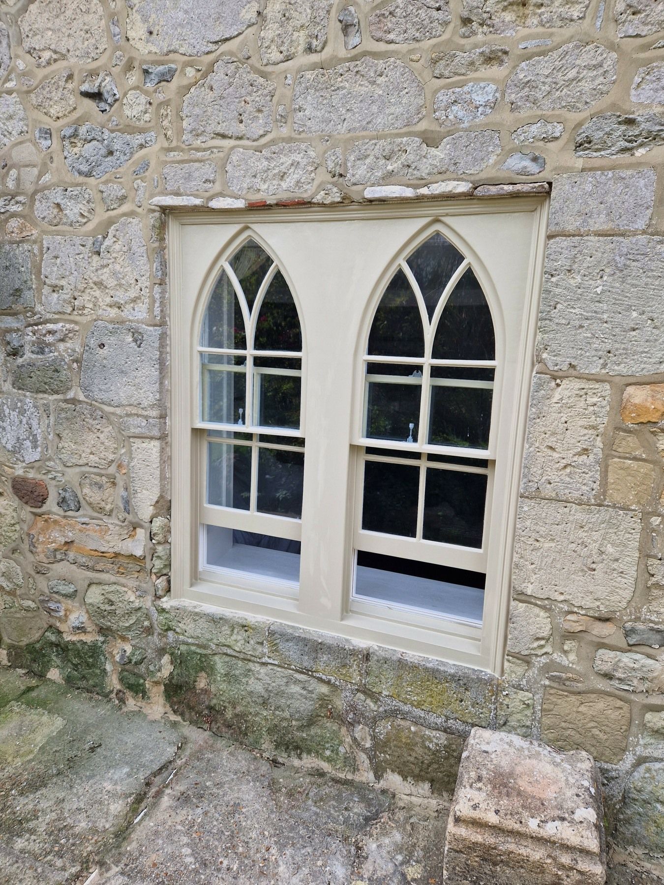 a stone wall with gothic arched windows