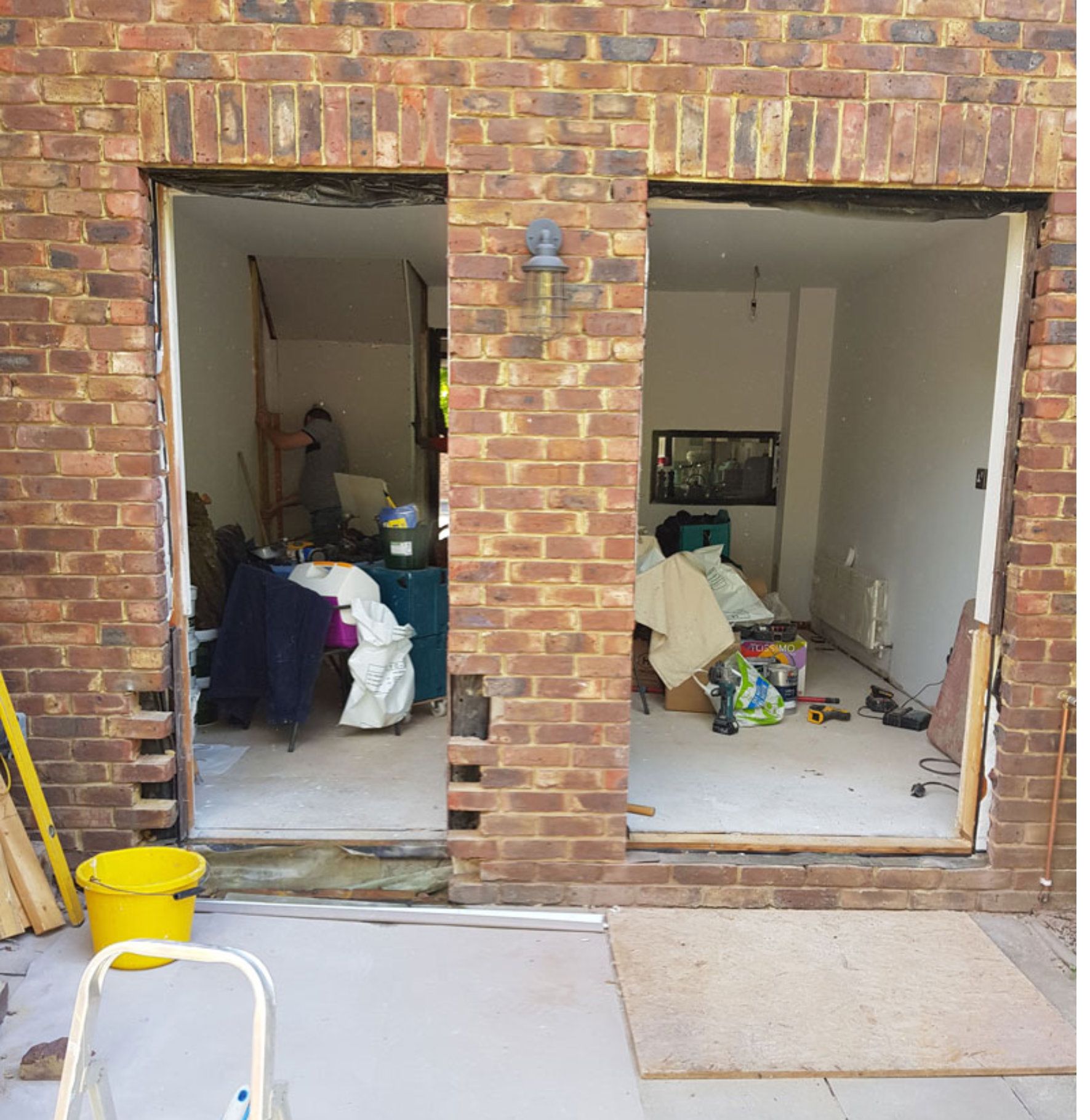 A brick building with a sliding glass door between two rooms