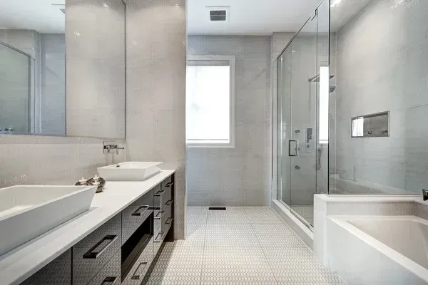 A bathroom with two sinks , a tub and a walk in shower.