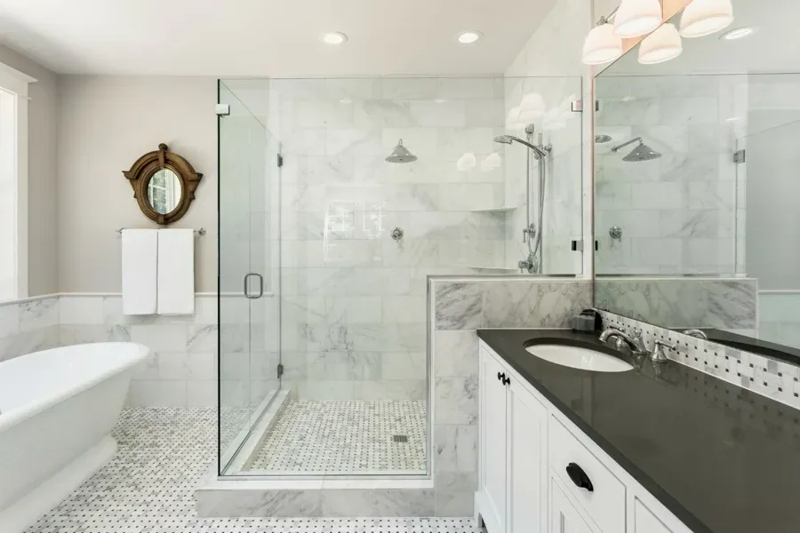 A bathroom with a tub , sink , mirror and walk in shower.