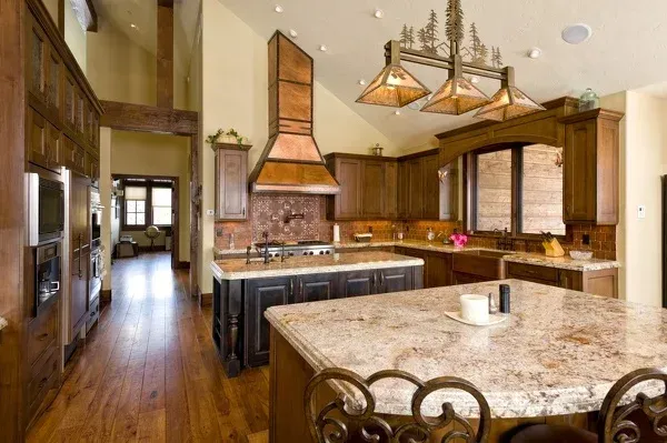 A kitchen with a large granite counter top and wooden cabinets