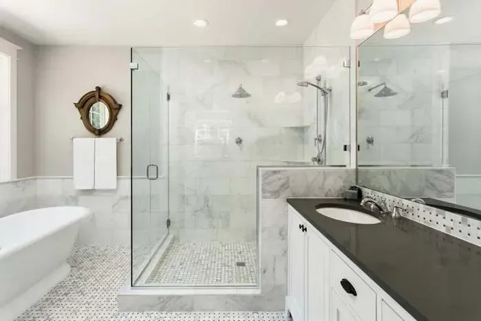 A bathroom with a walk in shower , tub , sink and mirror.