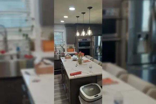 A kitchen with a large island and a trash can.