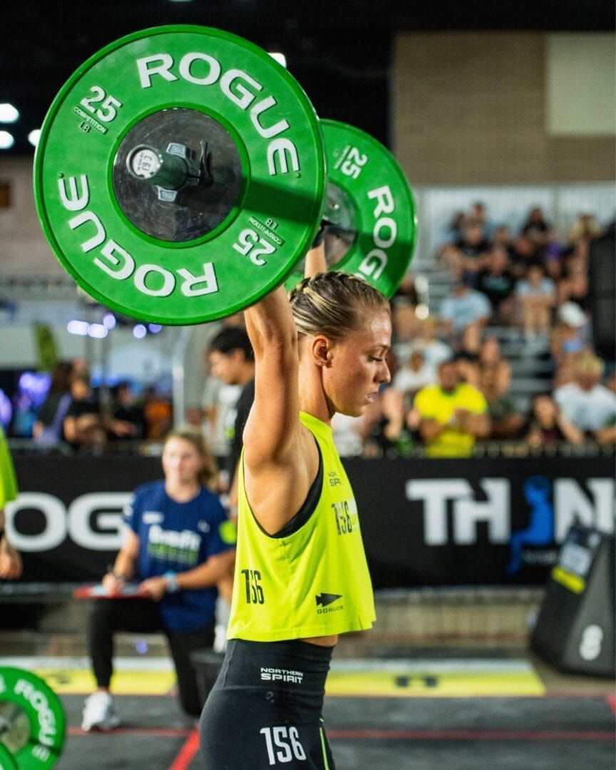 A woman is lifting a barbell over her head.