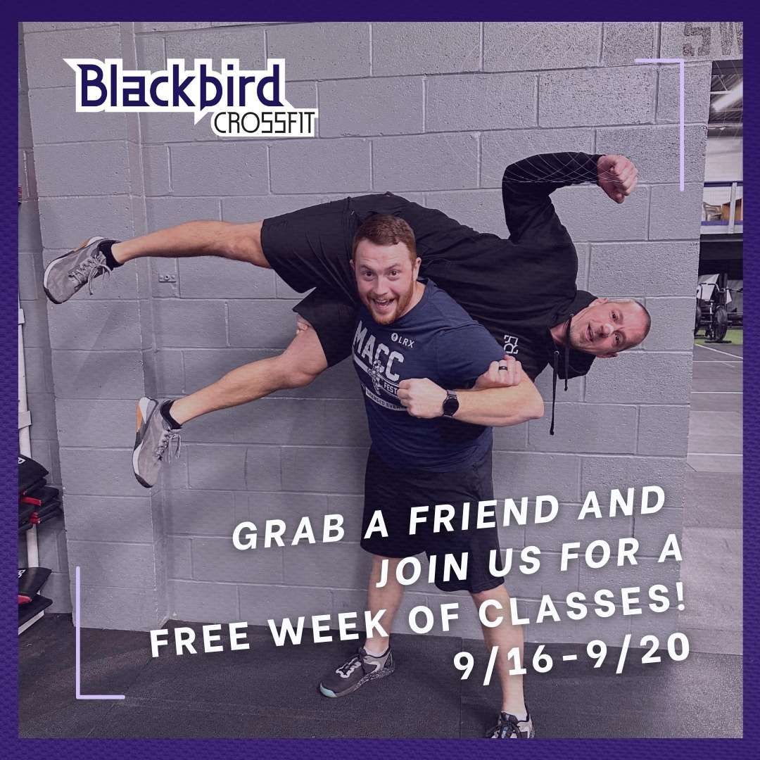Two men are standing next to each other in front of a brick wall.