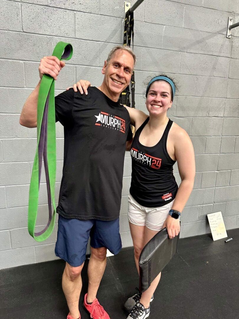 A man and a woman are posing for a picture in a gym.