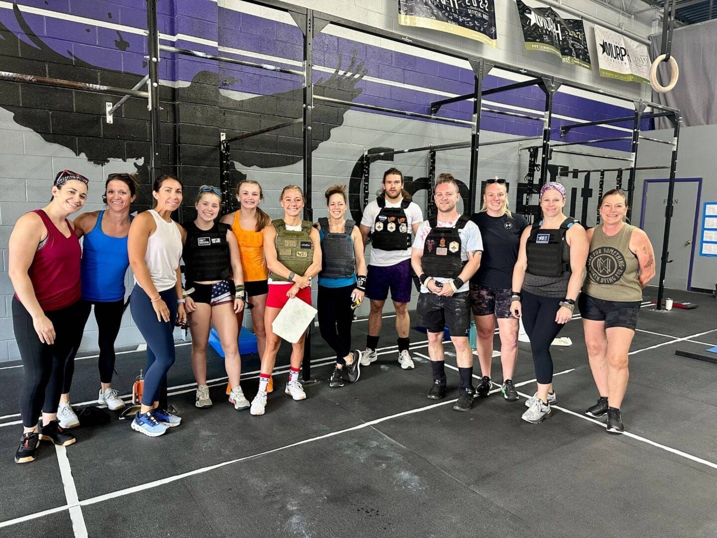 A group of people are posing for a picture in a gym.