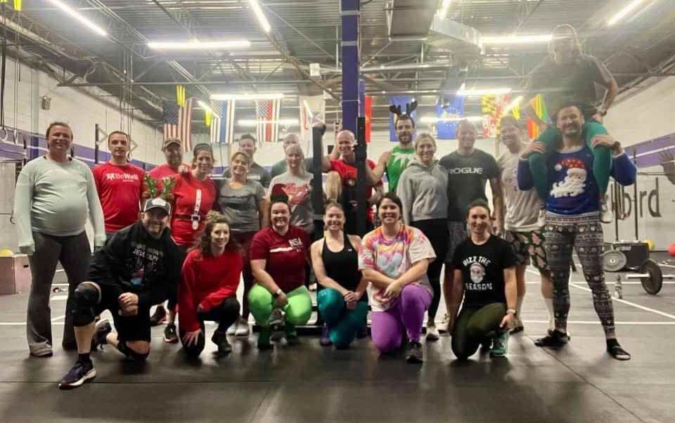 A group of people are posing for a picture in a gym.
