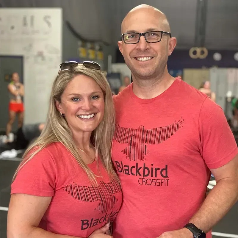 A man and a woman are posing for a picture in a gym.